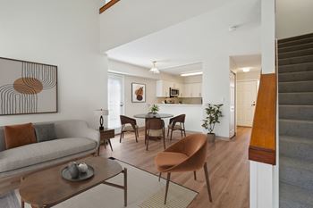 A living room with a couch and a table and a kitchen with a dining room